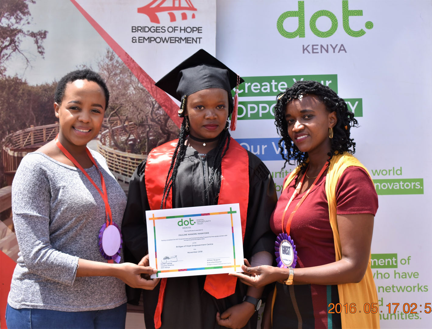 Three women holding a diploma and smiling for the camera.