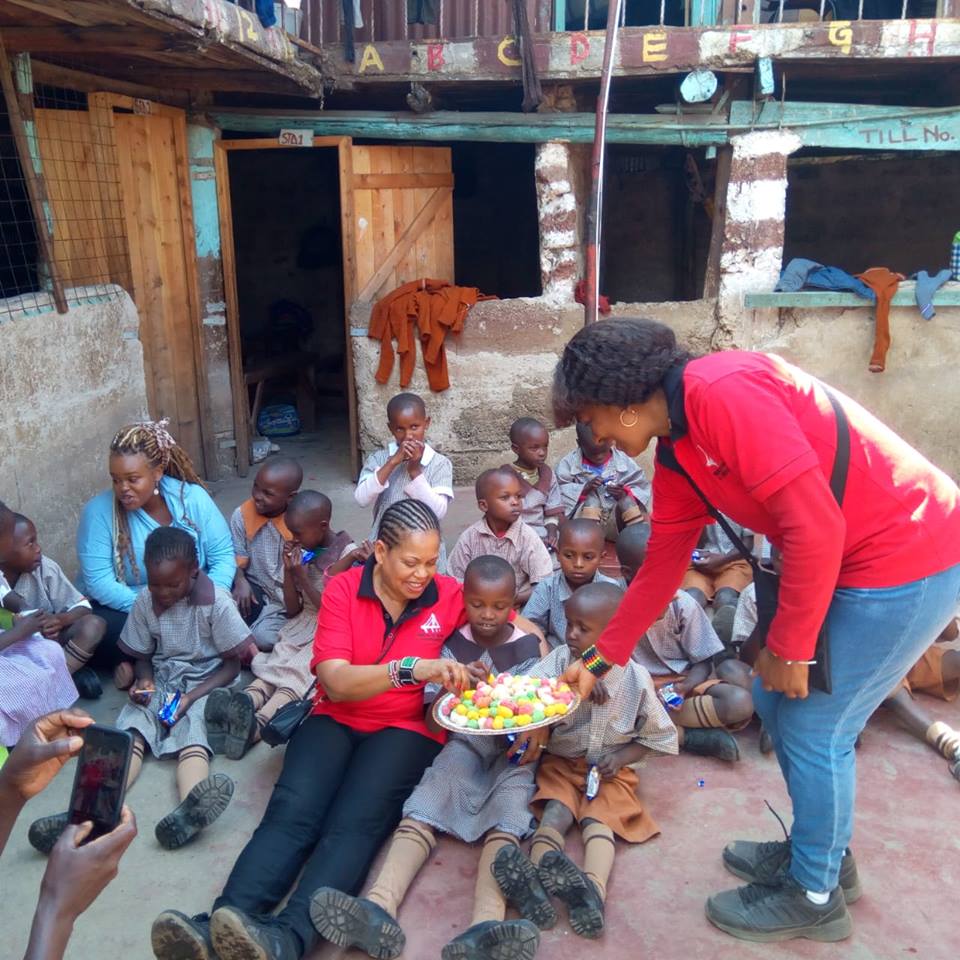 A woman handing food to children in the street.