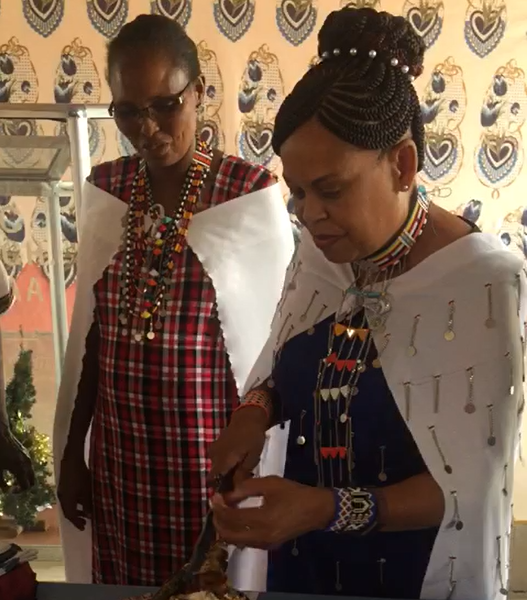 Two women in traditional dress looking at a cell phone.