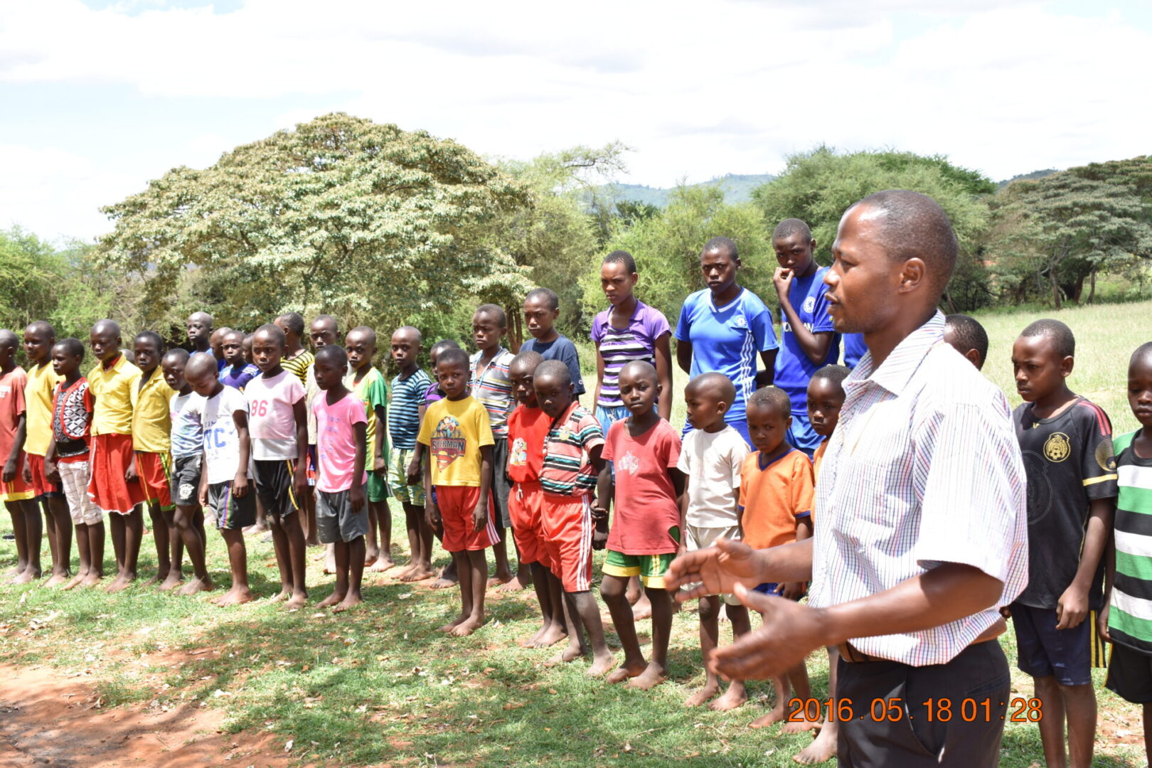 A man standing in front of a group of children.