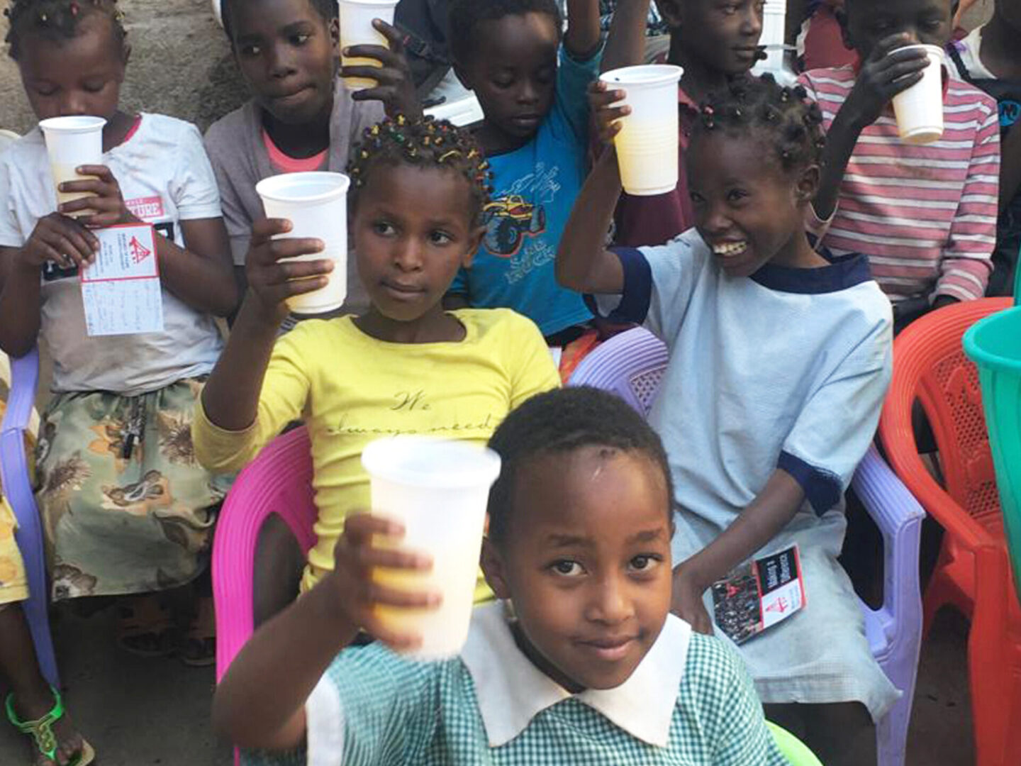 A group of children holding cups in their hands.
