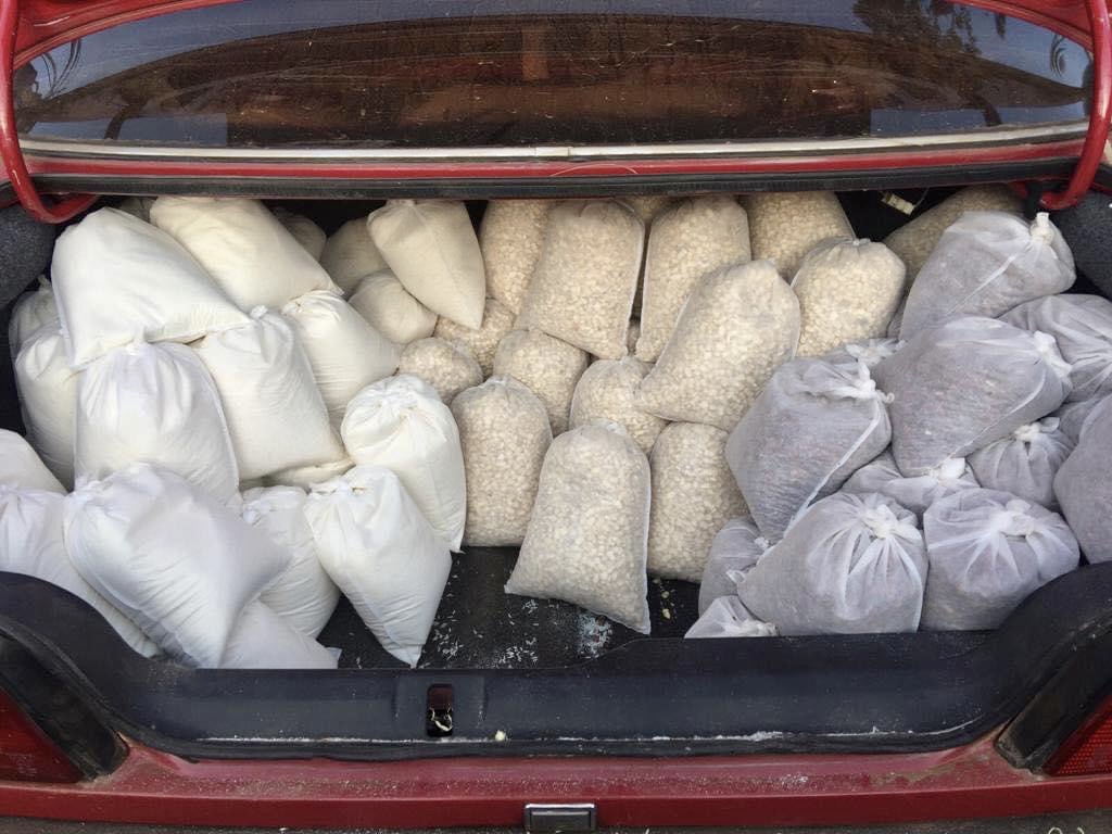 A trunk filled with bags of white stuff.