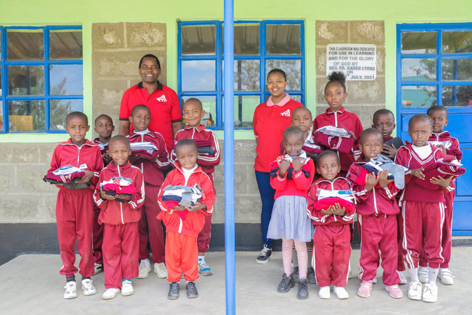 A group of children in red shirts holding books.