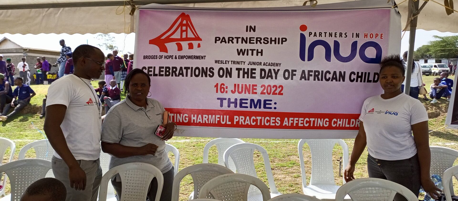 A woman sitting in front of a banner.